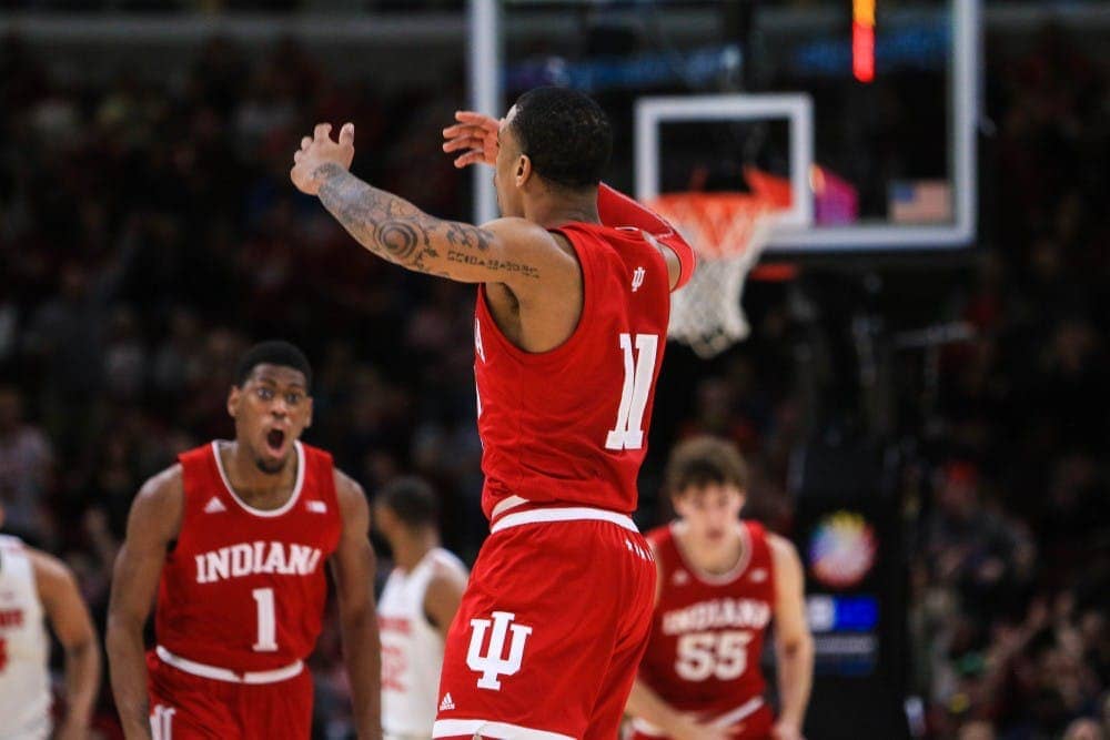 Indiana Hoosiers basketball player jumping in celebration with teammates in the background